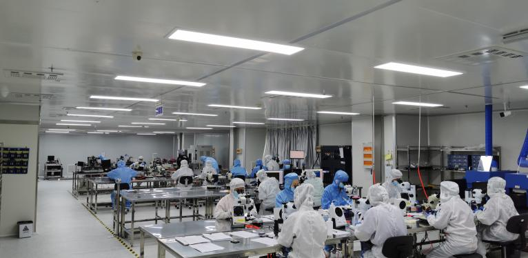 Technicians carrying out laser source assembly in a controlled cleanroom