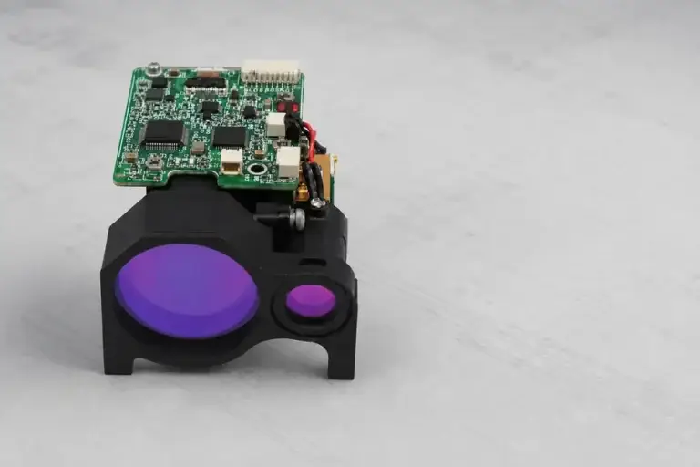 Lumexis laser rangefinder module shown with its optical apertures and interface board.