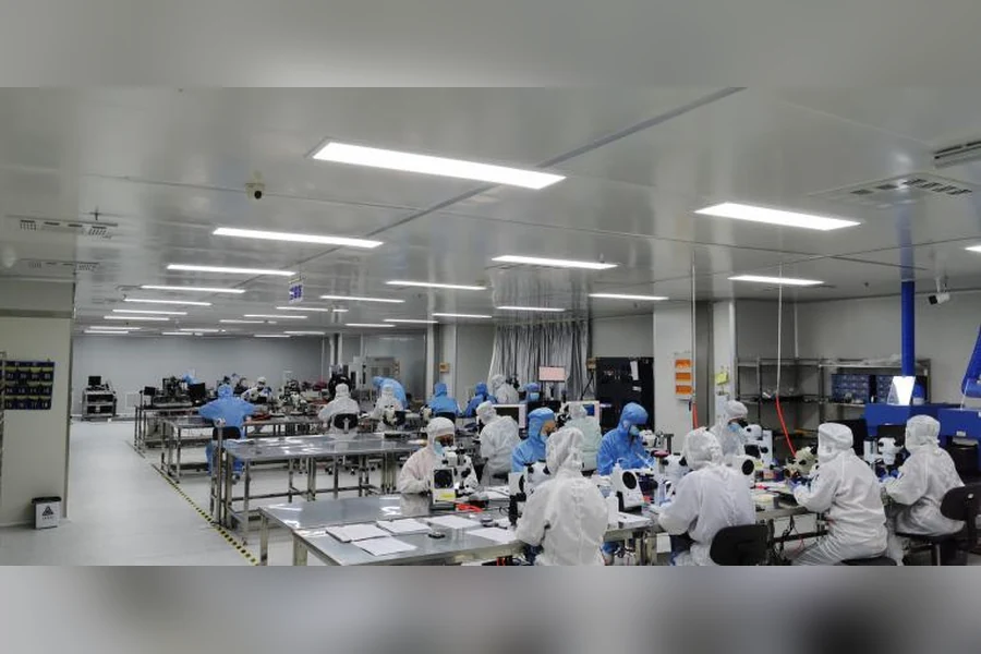 Reinraumtechniker, die kontrollierte optische Montage und Inspektion für eine reproduzierbare Lasermodulproduktion durchführen.